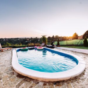 A cozy outdoor pool with a scenic sunset view.