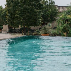 Serene outdoor pool surrounded by lush greenery and trees.