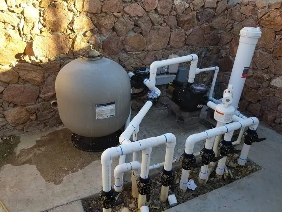 Outdoor water filtration system with connected pipes and valves.