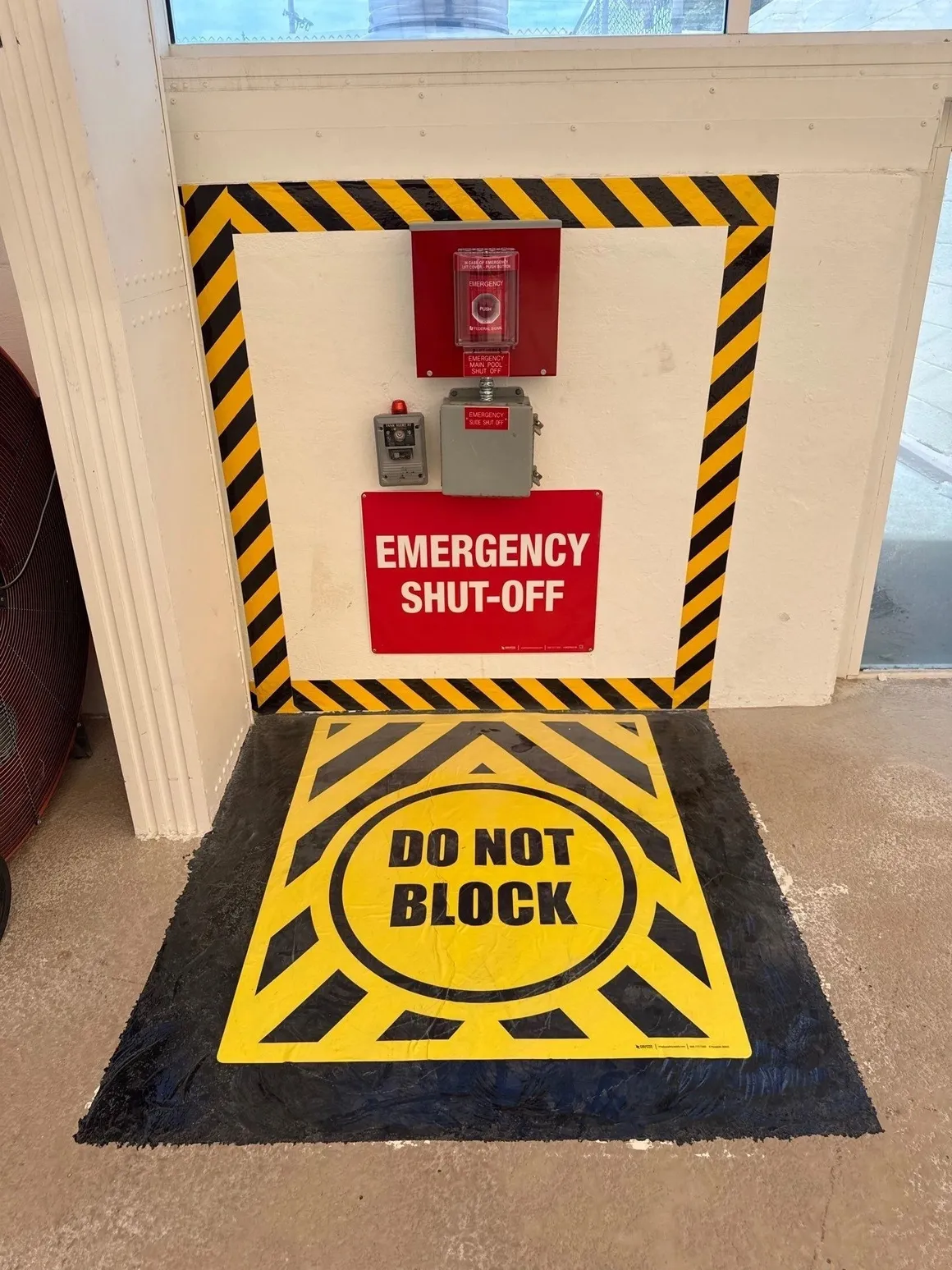 Emergency shut-off switch with caution signs to keep area clear.
